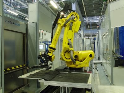 在工件的初始加工后，机器人立即将半成品部件运送到洗衣机。
